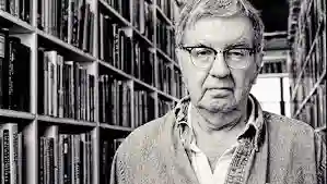 Larry McMurtry smiling warmly in a casual outdoor portrait.