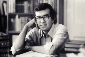 Larry McMurtry examining books in what appears to be his famous bookstore.